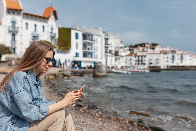 Traveler sitting on the ground near the water edge