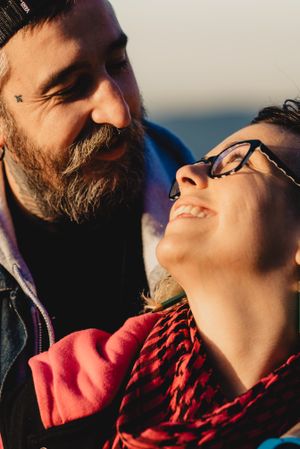 Happy couple hugging near tree in park