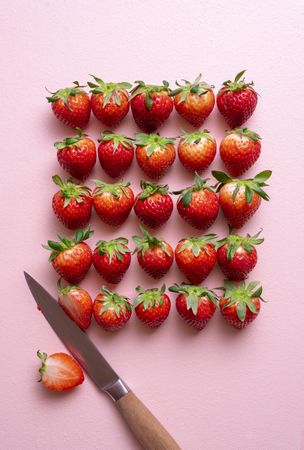 Fresh strawberries arranged on a pink table