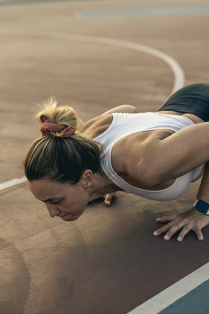 Determined woman doing a push-up exercise during an intense outdoor workout
