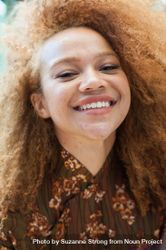 Close up portrait of young woman with afro smiling at the camera 5RVr25