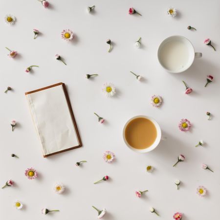Vintage notebook on light background with colorful flowers and cup of coffee and milk