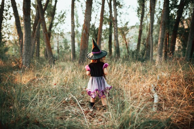 Back of young girl in the forest at halloween