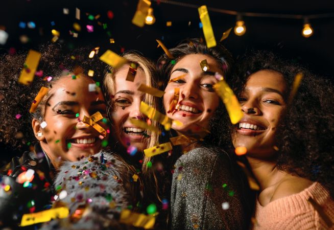 Multi-ethnic group of happy women with confetti falling around