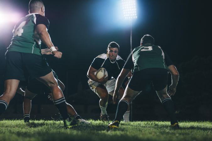 Professional rugby action under lights at sports arena