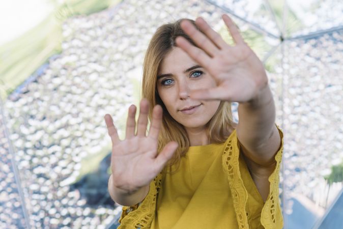 Young smiling woman pulling hands to camera
