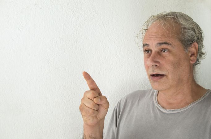 Man in gray shirt pointing with his finger