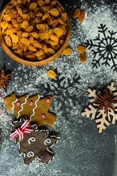 Top view of flour on counter with Christmas baking ingredients and snow flakes