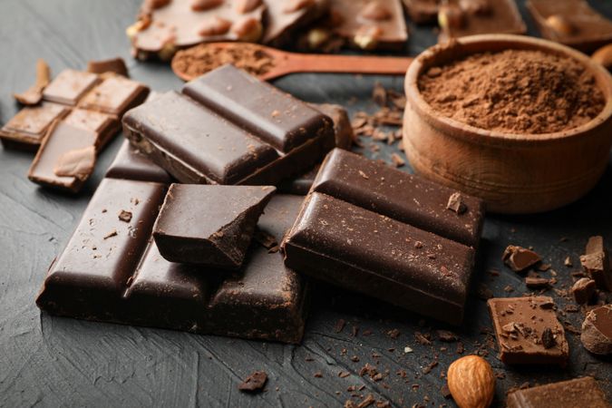 Chocolate, melted chocolate and almond on dark background