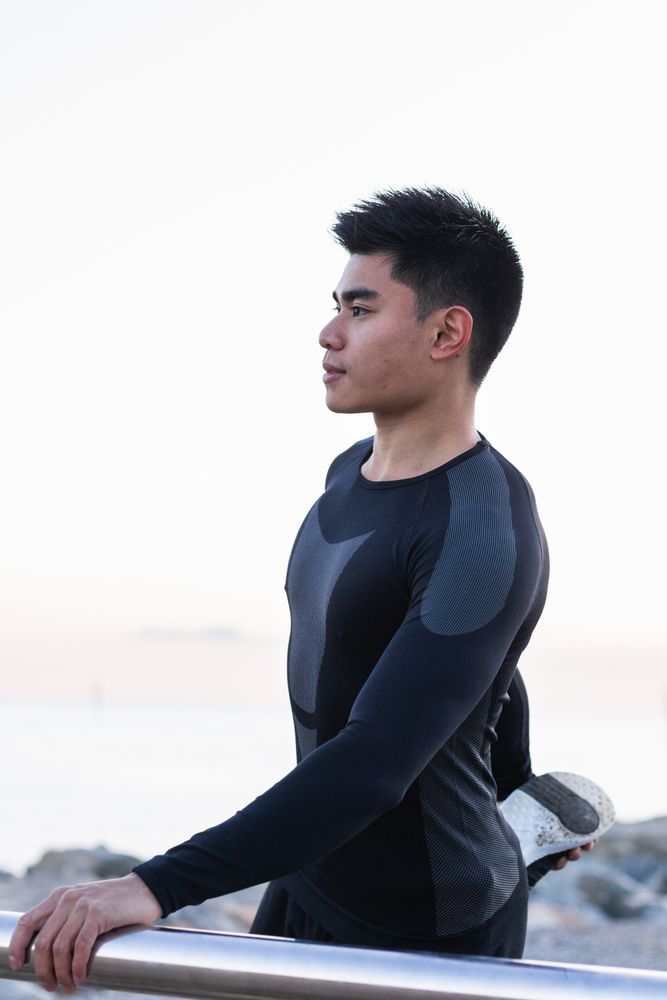 Asian man stretching legs during outdoor workout