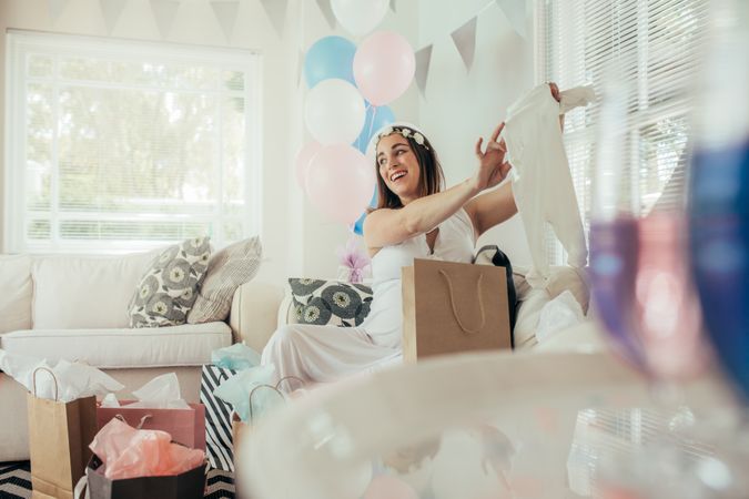 Pregnant woman with new gift at baby shower