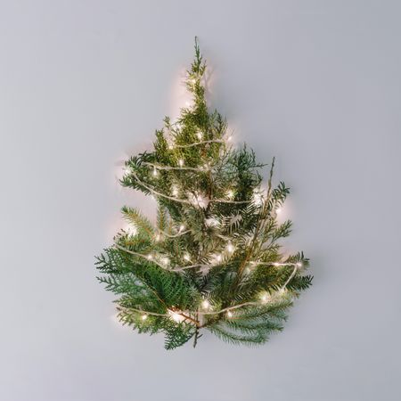 Christmas tree with lights on pastel gray table top