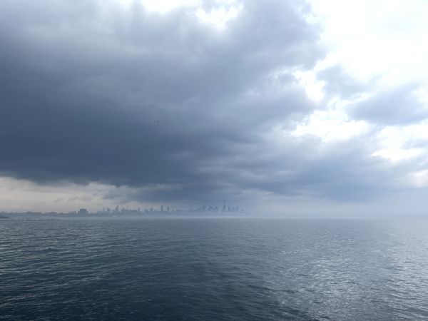 Foggy Toronto skyline under stormy clouds