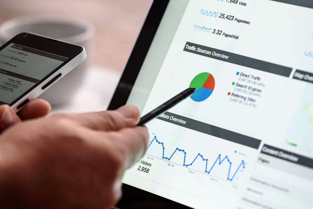 Cropped image of a hand holding a pen pointing at pivot table