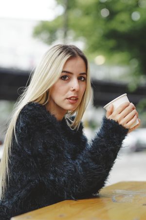 woman drinking coffee in street cafe