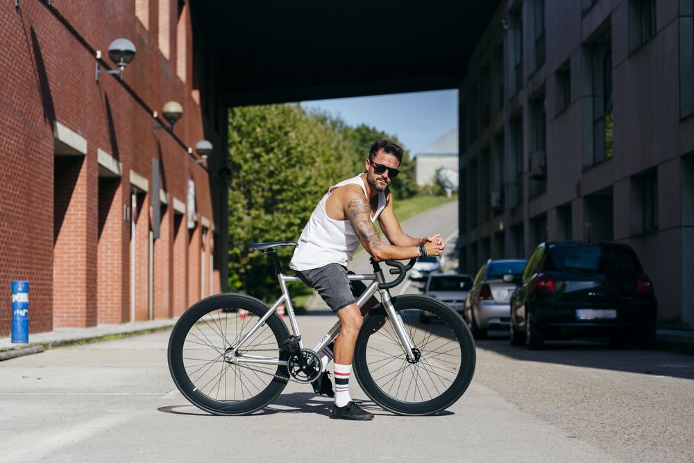 Man riding bike next to buildings