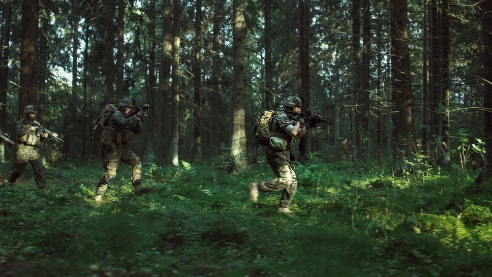Fully Equipped Soldiers Wearing Camouflage Uniform Attacking Enemy, Rifles in Firing Position.