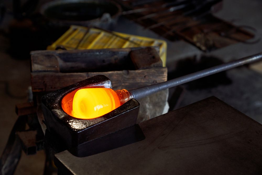 Molten glass being shaped before being blown