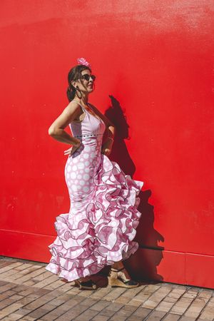 Passionate woman in flamenco dress dancing on street