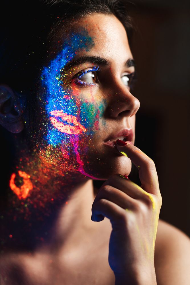 Young woman covered with uv painting