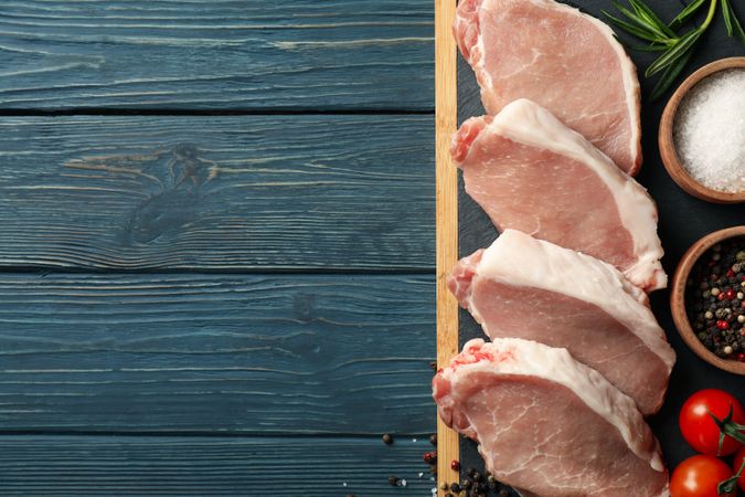 Composition with raw meat for steak and ingredients on wooden background