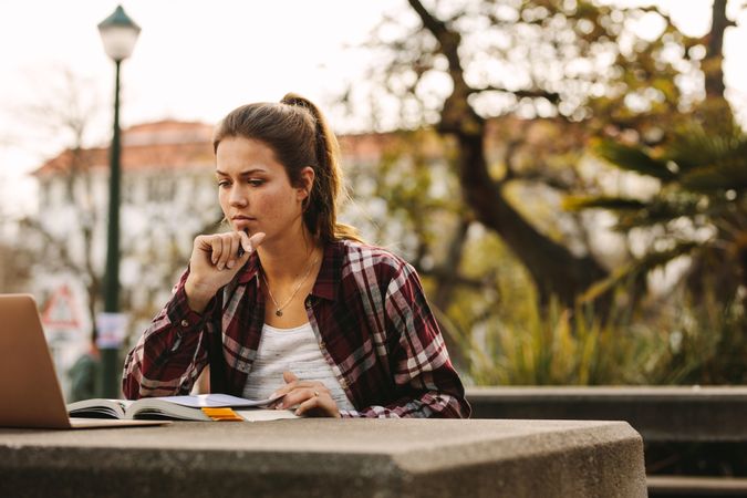 Female student preparing notes for exams at college campus