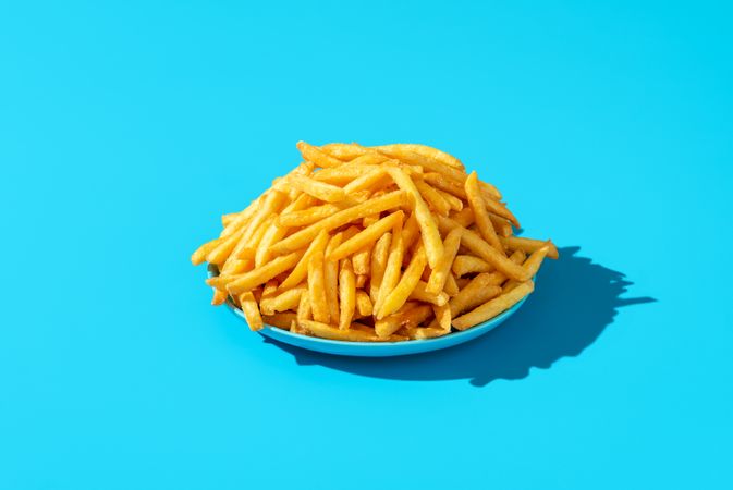 French fries plate minimalist on a blue background