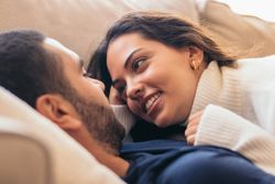 Romantic stock photo of young couple on sofa at home