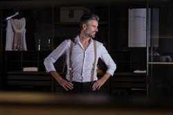 Delightful good looking adult man against wardrobe