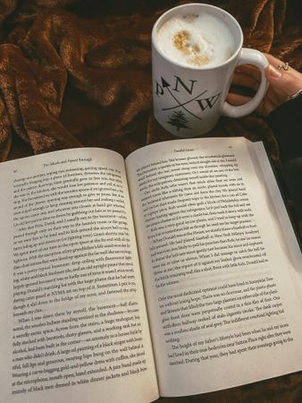 Cup of coffee beside an open book