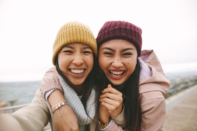 Two happy young female friends smile and take selfie