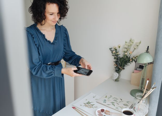 Artist photographing drawings with smartphone