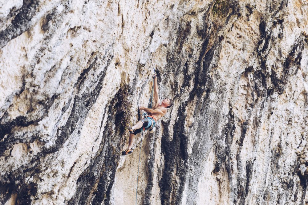 Anonymous man climbing rock