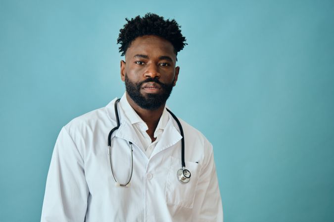 Black male doctor in blue studio