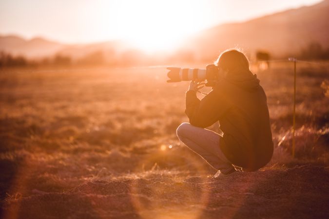 Man shooting on camera beautiful landscape between hills