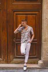 Man talking on phone leaning on door