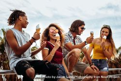 Smiling young men and women eating ice-cream outdoors 5XVm7b