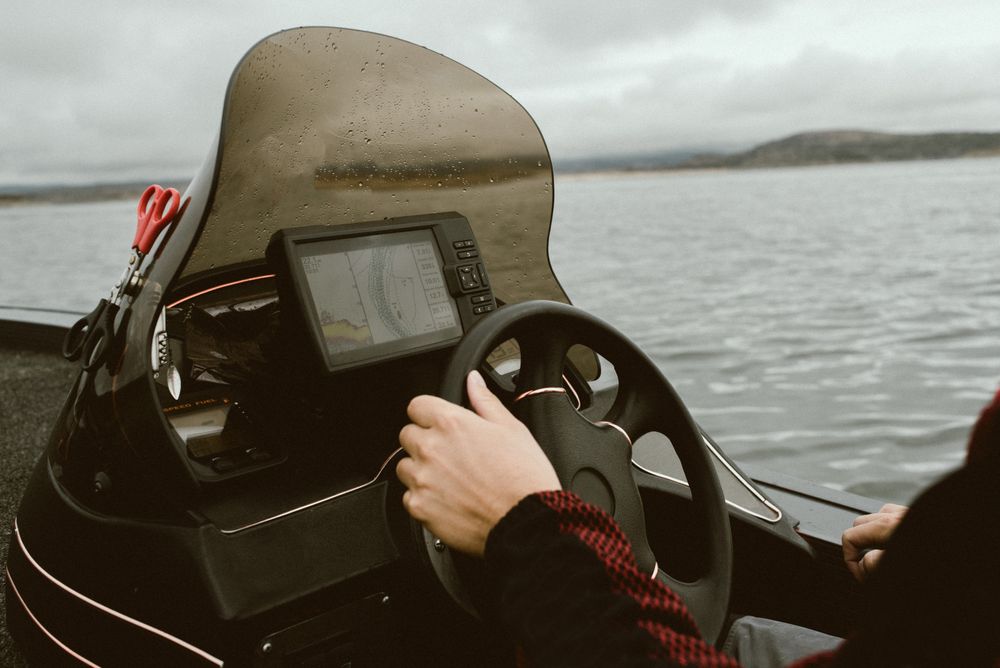 Tourist leading boat on high seas under control of navigator
