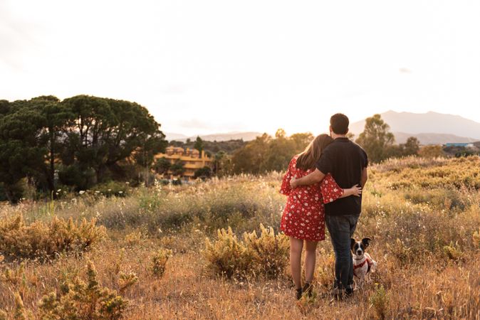 Happy couple with friendly cute dog outdoors