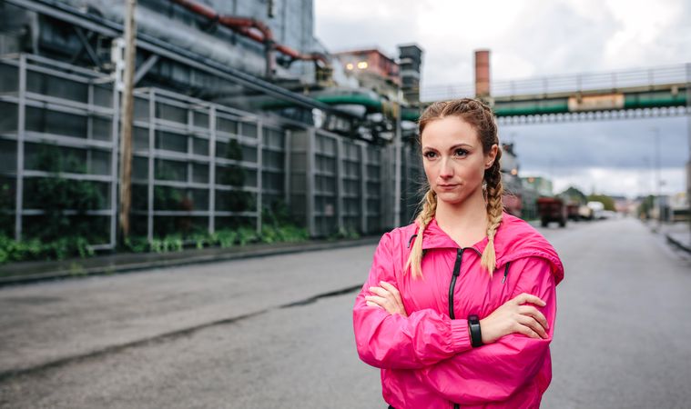 Sportswoman with boxer braids posing in front of a factory