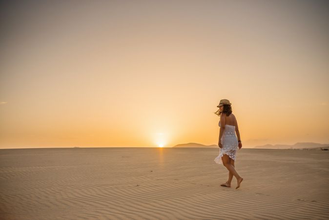 Active woman walking in dry desert barefoot