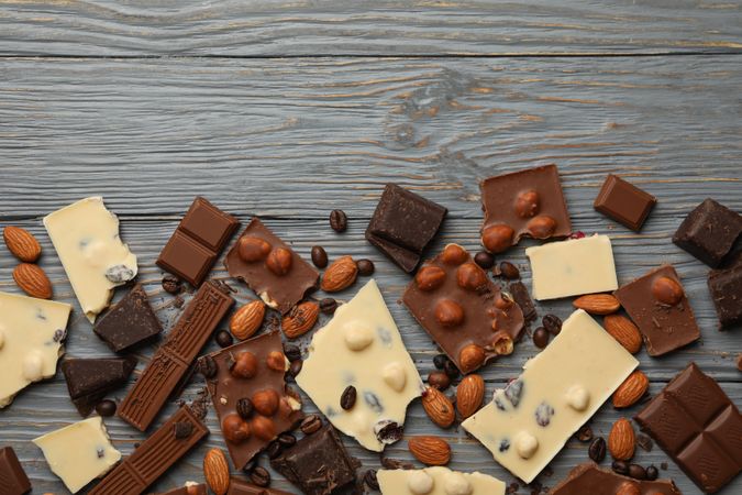 Different chocolate on gray wooden background, top view