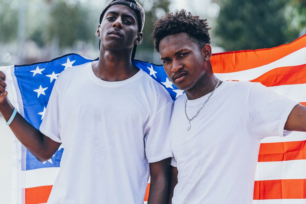 Black men in American Flag outside