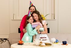 Birthday girl embraces her mother and sister