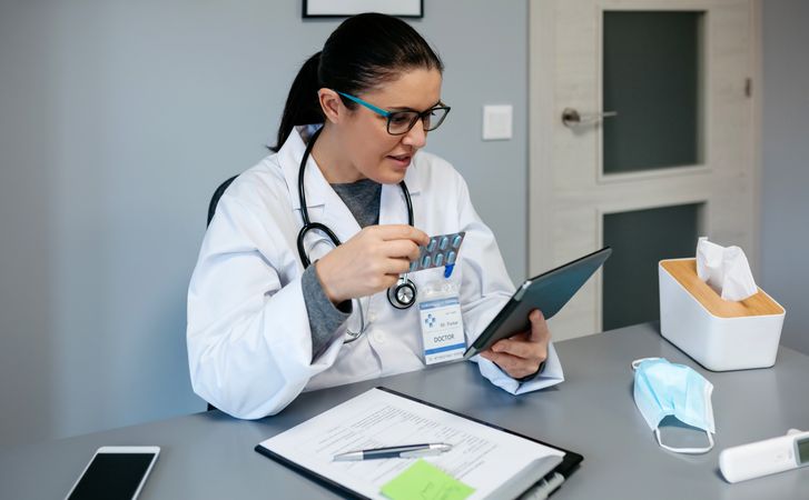 Female doctor doing online consultation showing pills for treatment