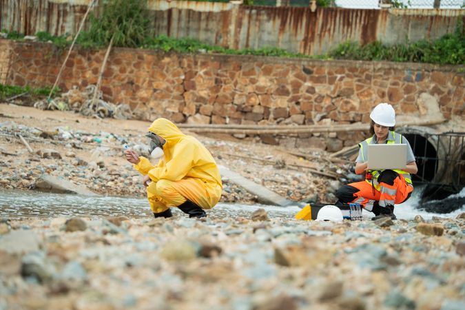 Environment scientist with team analysing waste water collecting sample for research