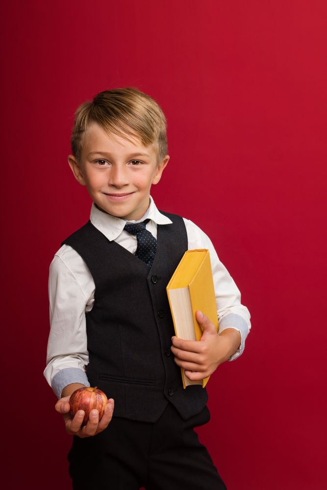 Cute guy hold yellow book and apple