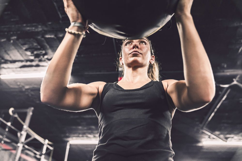 Muscular woman exercising with ball in gym