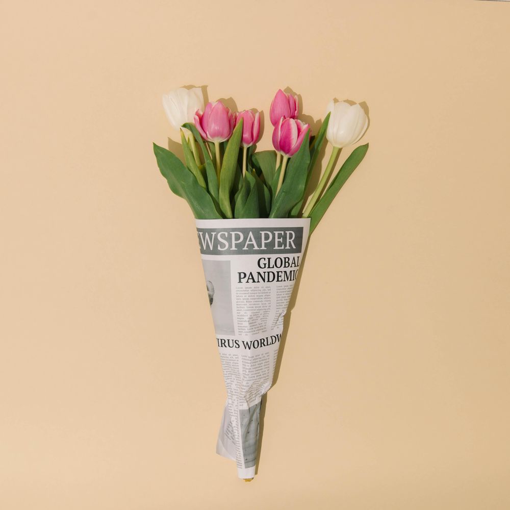 Spring tulips flowers wrapped in newspapers with Global Pandemic headline