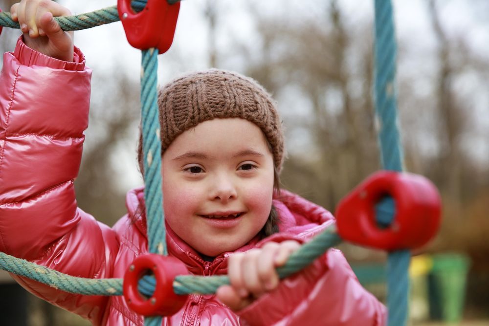 Close up of child climbing rope on playground set